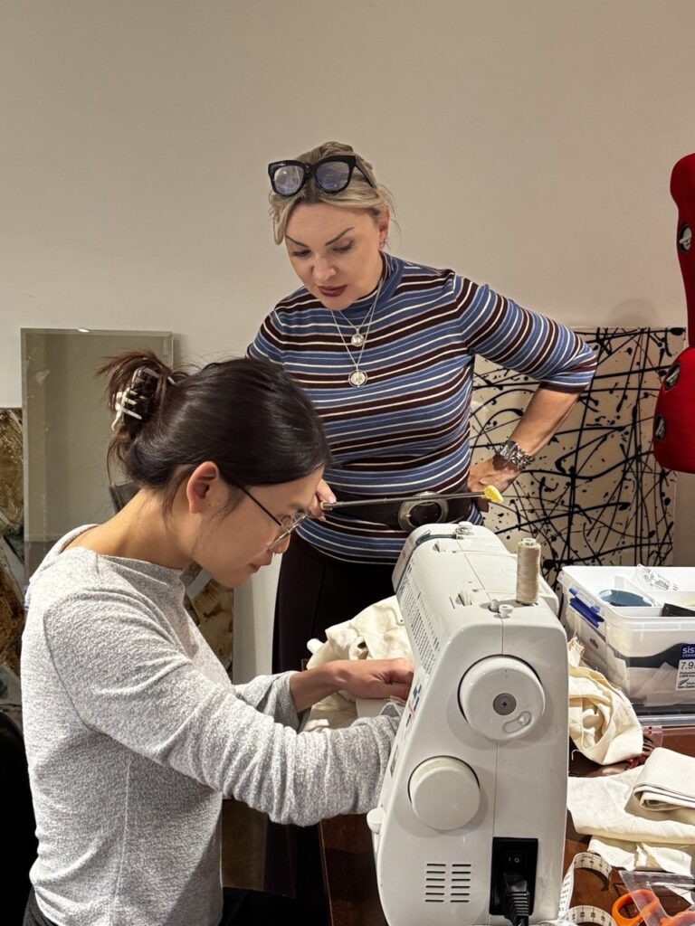Sewing together at Sewciety Two Sewciety participants working together at a sewing machine
